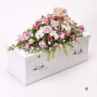 <h2>Pink and White Children's Casket Spray with Teddy Bear | Funeral Flowers</h2>
<ul>
<li>Approximate Size 70cm x 30cm</li>
<li>Hand created classic pink and white casket spray in fresh flowers</li>
<li>To give you the best we may occasionally need to make substitutes</li>
<li>Funeral Flowers will be delivered at least 2 hours before the funeral</li>
<li>For delivery area coverage see below</li>
</ul>
<br>
<h2>Liverpool Flower Delivery</h2>
<p>We have a wide selection of casket flowers offered for Liverpool Flower Delivery. Casket flowers can be provided for you in Liverpool, Merseyside and we can organize Funeral flower deliveries for you nationwide. Funeral Flowers can be delivered to the Funeral directors or a house address. They can not be delivered to the crematorium or the church.</p>
<br>
<h2>Flower Delivery Coverage</h2>
<p>Our shop delivers funeral flowers to the following Liverpool postcodes L1 L2 L3 L4 L5 L6 L7 L8 L11 L12 L13 L14 L15 L16 L17 L18 L19 L24 L25 L26 L27 L36 L70 If your order is for an area outside of these we can organise delivery for you through our network of florists. We will ask them to make as close as possible to the image but because of the difference in stock and sundry items it may not be exact.</p>
<br>
<h2>Liverpool Funeral Flowers | Casket Flowers</h2>
<p>This children's casket spray has been loving handcrafted by our expert florists. Bramble Bear sits amongst a sea of pink and white flowers, creating a fitting tribute for a little girl. Roses and calla Lily in soft pink shades are arranged with white freesia, September flowers and deep pink lisianthus and finished with seasonal foliages.</p>
<br>
<p>Funeral Casket Flowers the main tribute and are sometimes, depending on the family's wishes, the only flower arrangement. They are usually chosen by the immediate family.</p>
<br>
<p>Casket sprays are placed directly on top of the coffin. The sprays are large diamond shape tributes. The flowers are arranged in floral foam, which means the flowers have a water source meaning they look their very best for the day.</p>
<br>
<p>Containing 3 pink roses, 5 pink calla lilies, 4 white freesia, 3 pink lisianthus, 2 white September flower and seasonal mixed foliage together with a soft teddy bear who sits in the middle of the casket spray.</p>
<br>
<h2>Best Florist in Liverpool</h2>
<p>Trust Award-winning Liverpool Florist, Booker Flowers and Gifts, to deliver funeral flowers fitting for the occasion delivered in Liverpool, Merseyside and beyond. Our funeral flowers are handcrafted by our team of professional fully qualified who not only lovingly hand make our designs but hand-deliver them, ensuring all our customers are delighted with their flowers. Booker Flowers and Gifts your local Liverpool Flower shop.</p>
<br>
<p><em>Janice Crane - 5 Star Review on Google - Funeral Florist Liverpool</em></p>
<br>
<p><em>I recently had to order a floral tribute for my sister in laws funeral and the Booker Flowers team created a beautifully stunning arrangement. Thank you all so much, Janice Crane.</em></p>